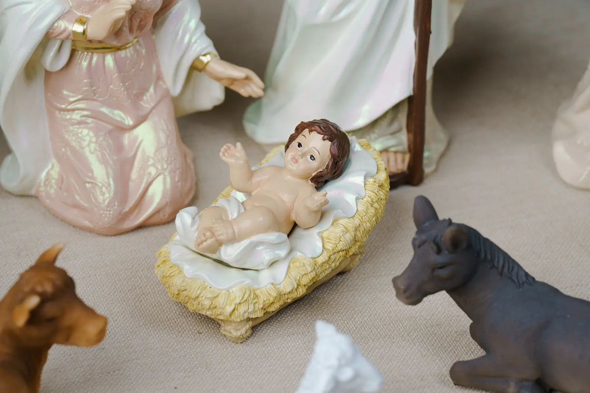 Pearlized Resin Nativity Figures in Blush Pink and Ivory with a Gloria Banner Angel and Straw Manger